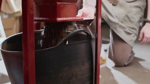 Unrecognizable Worker Operating Grinding Coffee Machine at Factory