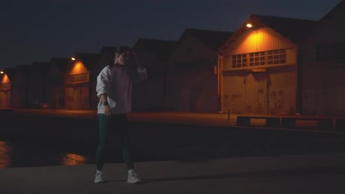 Determined Sporty Woman Doing Jumping Squats on Promenade at Night