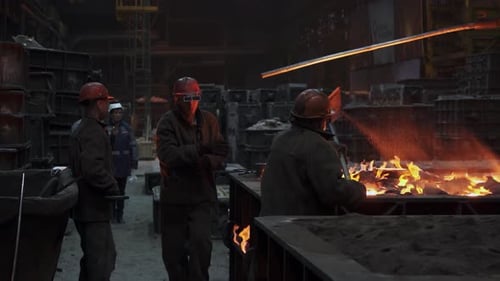 Workers in a Metal Foundry are Engaged in the Intricate Process of Pouring Molten Metal Stock Clip