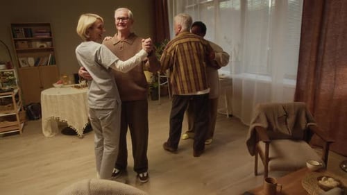 Seniors Dancing in Nursing Home with Female Caregiver