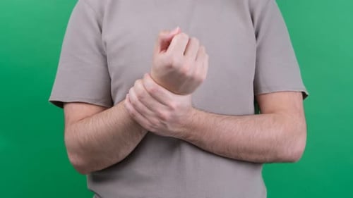 Adult Rubbing Sore Wrist on Green Screen