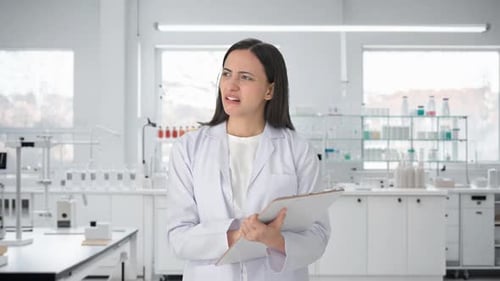 Woman Scientist Reviews Results in Bright Laboratory