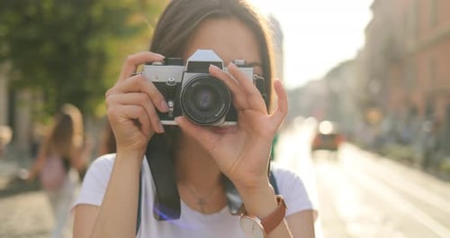 Smiling Woman with Vintage Camera in City Street