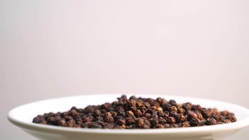Pile of Black Peppercorns on Plate