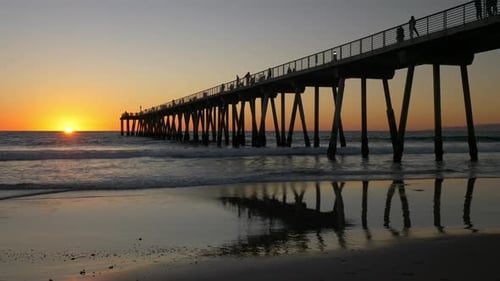 Pier at Sunset Along Tranquil Beach Shoreline