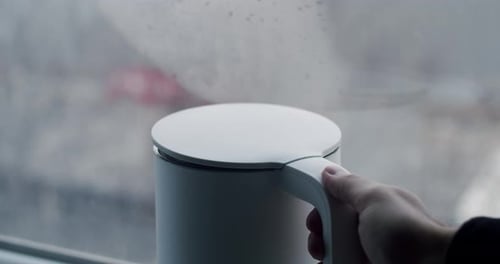 Hand Opens Modern Kettle in Close Up Studio Shot