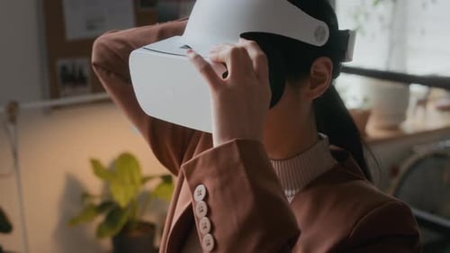 Female Developer Using Headset while Testing VR Application in Office