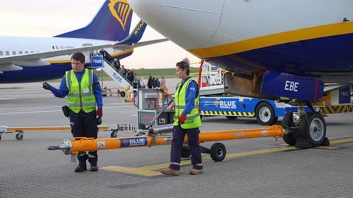 Worker in Yellow Jacket Working and Maintaining the Ryanair Airplane