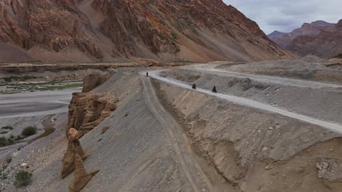 Riders Travel Dusty Trail Through Canyon