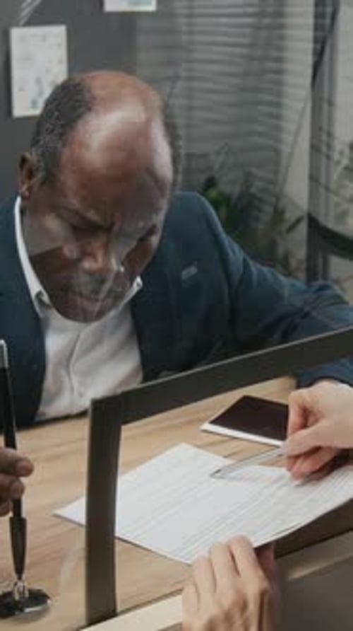 Man Signing Document at Bank Teller Window