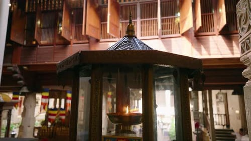 Traditional Oil Lamp Burns at Buddhist Temple Intricate Design Warm Glow Amid Historic Architecture