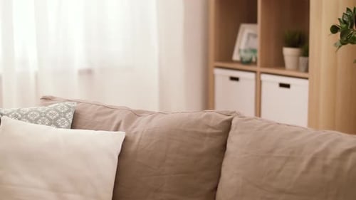 Smiling Girl Plays Peek-a-boo Behind the Sofa
