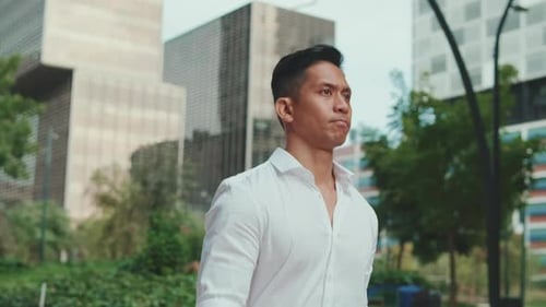Young businessman is walking on modern building background
