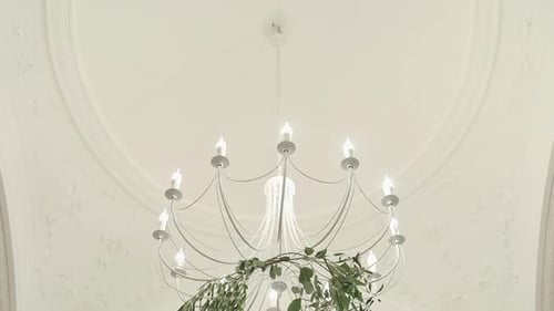 Eleganter Kronleuchter, der unter einer verzierten Decke hängt