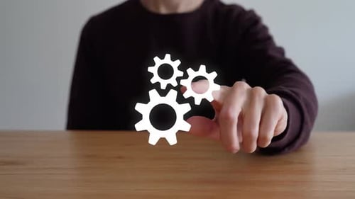 Persona toca los tres íconos de engranaje entrelazados que representan la configuración. - primer plano