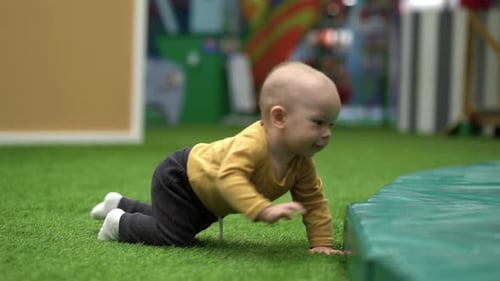 Einjähriges Kind krabbelt auf dem Spielplatz