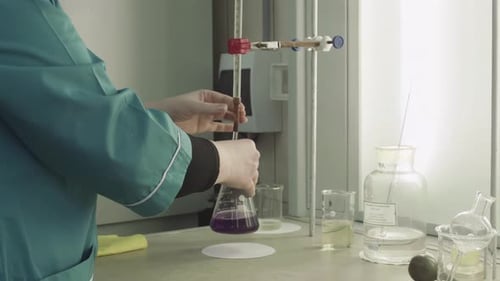 Scientist Titrating Liquid in Laboratory Beaker