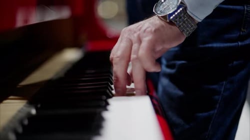 Close up of a man playing a red piano