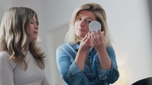 Mutter und Tochter schminken sich zu Hause zusammen