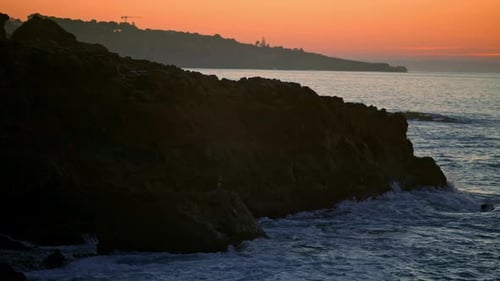 Mountain Hill Silhouette at Sunset Sea Beach. Dark Cliff at Calm Ocean