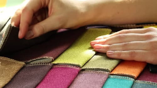 Hands selecting colorful fabric samples