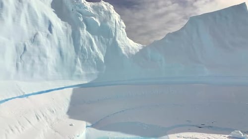 Glacier majestueux flottant sur la côte de l'Antarctique au coucher du soleil, vue aérienne