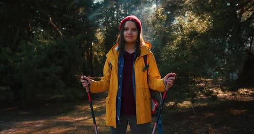 Backpacker Hiker Girl with Hiking Poles Walking Between Trees in a Mountain Forest Hispanic Teenager