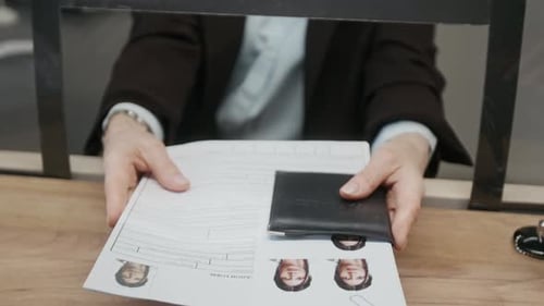 Anonymous Female Consulate Official Handing Documents to Applicant