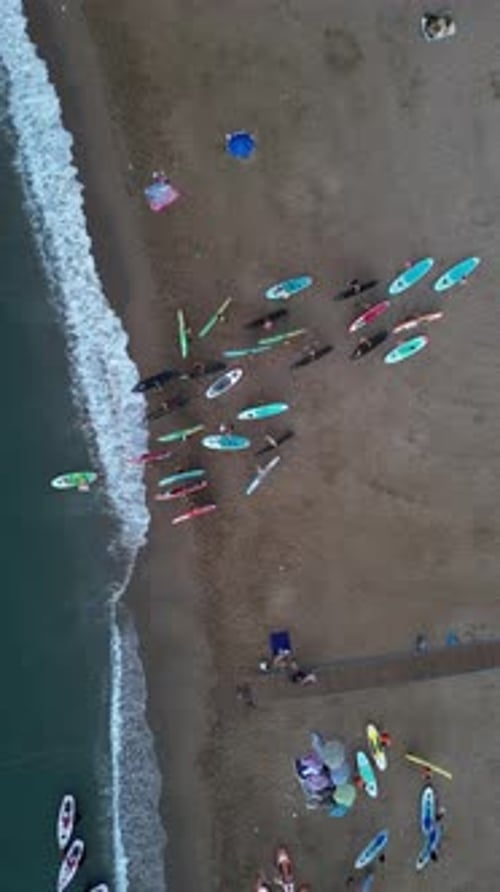 Aerial video on Barcelona's coastline people doing a sap.