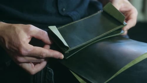 Close Up of Hands Inspecting Leather Wallet