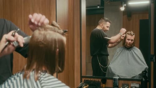 Young Red-Haired Caucasian Man Getting Haircut from Cheerful Barber