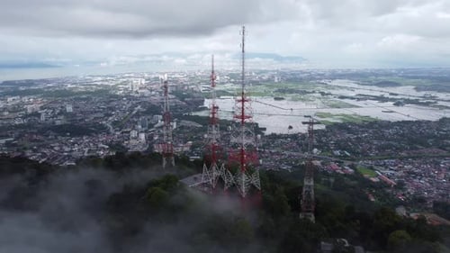 Aerial surround the telecommunication tower in low cloud at top