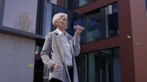 Woman Uses Voice Command in Urban Setting
