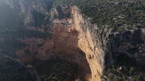 Der gewagte Jumper schwingt von einer Holzplattform über eine tiefe Schlucht