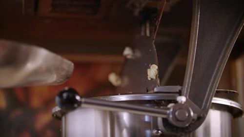 Woman Pouring Corn Kernels in Popcorn Machine. Process of Popcorn Production. Close