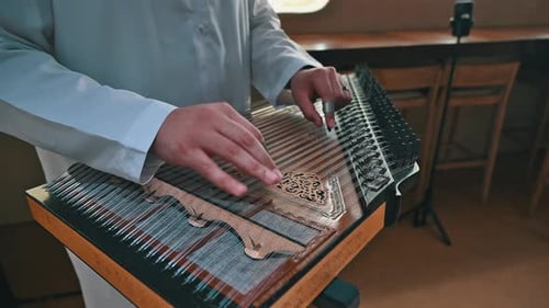 An Arab musician plays the qanun, producing intricate melodies that define the soul of Arabic music
