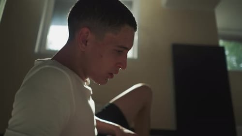 Un athlète épuisé se frotte les cheveux mouillés avec la main au gymnase