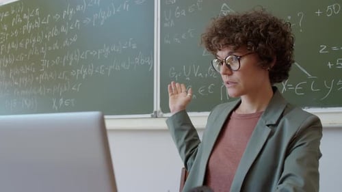Female Teacher Explains Math While Using Laptop