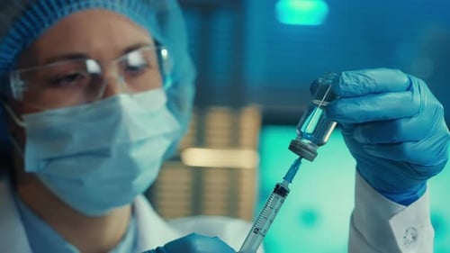 Doctor Drawing Vaccine into Syringe in Laboratory