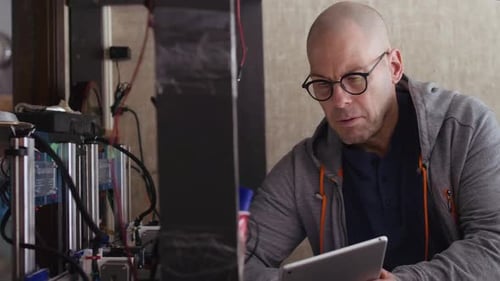 Man Works with Electronics and Tablet at Home