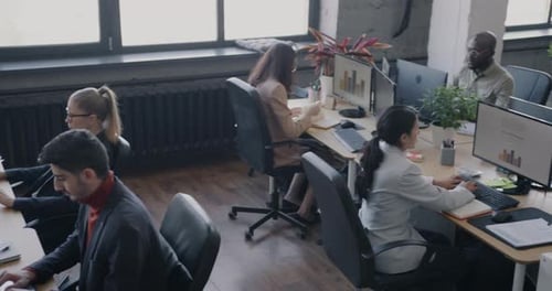 Vue en grand angle d'un centre de coworking très fréquenté avec un groupe diversifié d'employés travaillant à des bureaux