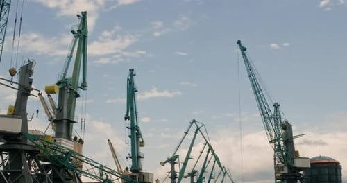 Loading Cranes on Cargo Ships on Blue Sky Background in Sea Port
