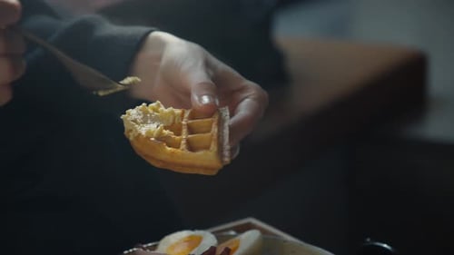 Woman Eating Waffle with Fork Inside Restaurant, Close Up