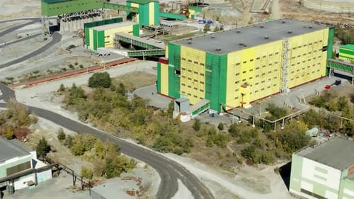 An Aerial View of an Industrial Complex Featuring Green and Yellow Buildings and Structures Stock