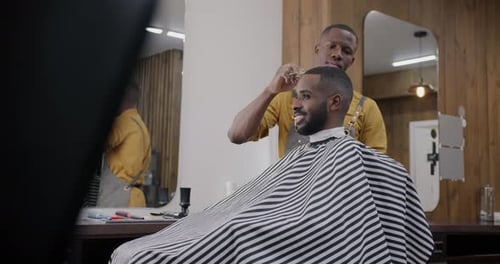 Man Getting Haircut by Barber in Stylish Barbershop
