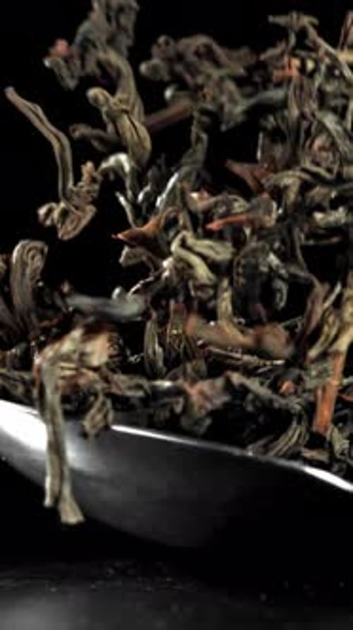 A Spoonful of Dry Tea Falls on the Table Filmed on a Highspeed Camera at 1000 Fps