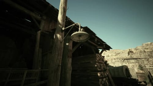 Vintage Lamp Hanging on a Rustic Wooden Structure in an Old Western Town