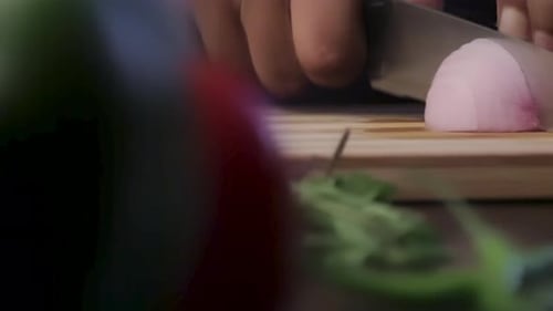 Hands Dicing Red Onion on Wooden Cutting Board
