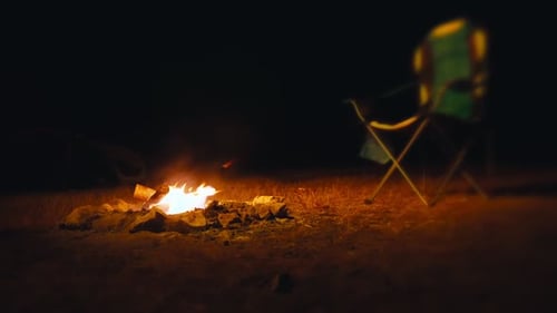Glowing Campfire at Night with Camping Tent