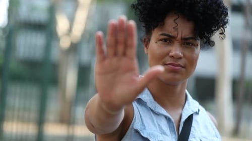 Young Woman Holds Hand Up as Stop Sign